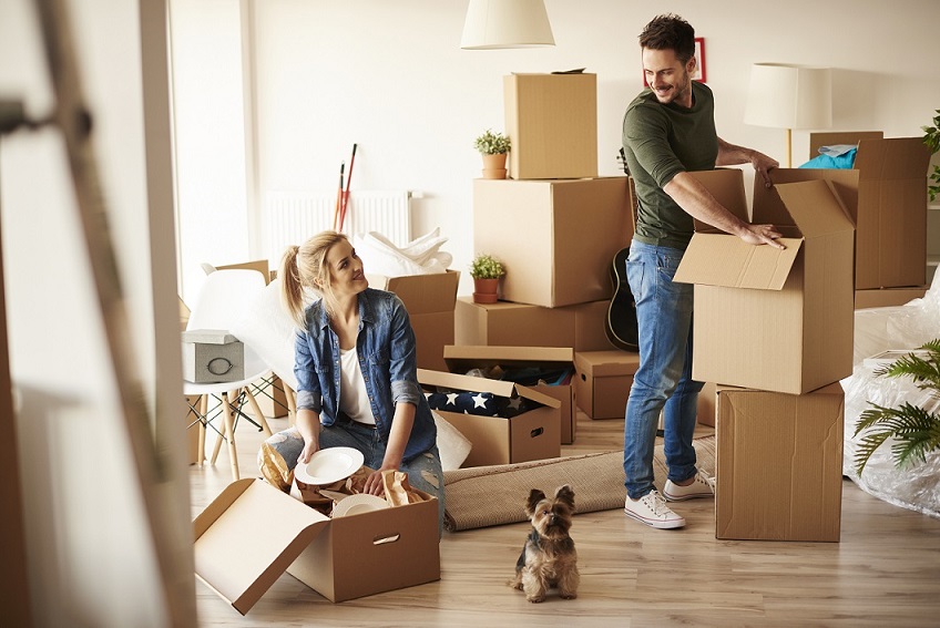 Young couple moving our of a house